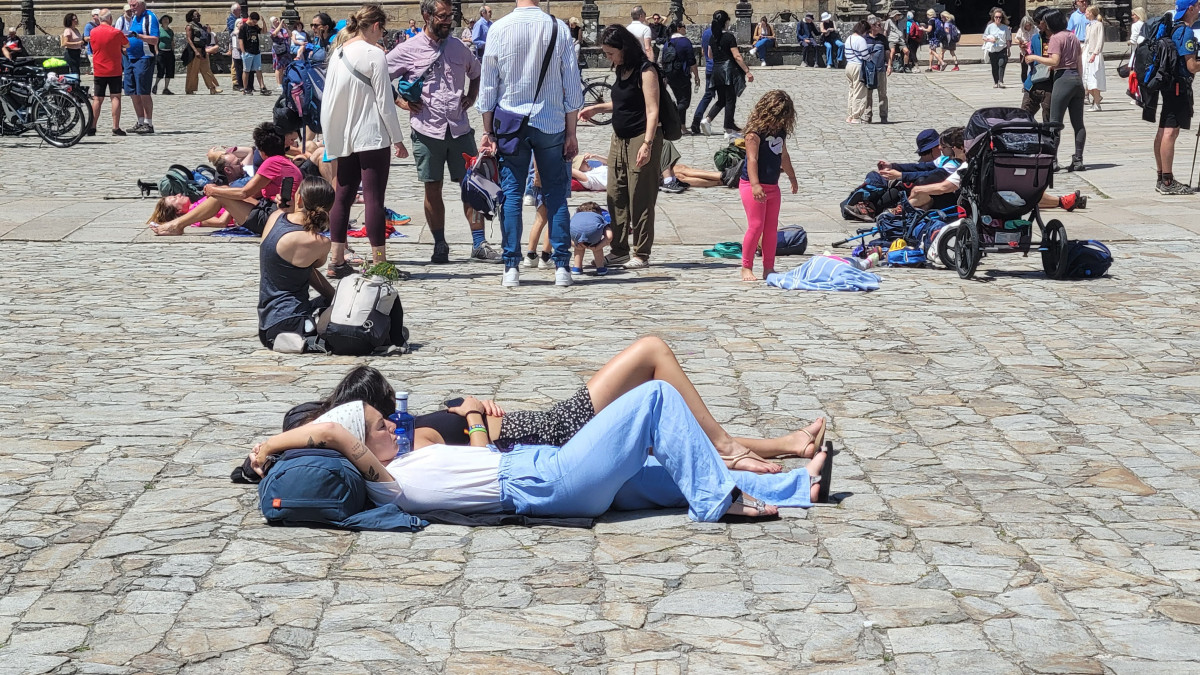 Turistas descansando en el Obradoiro