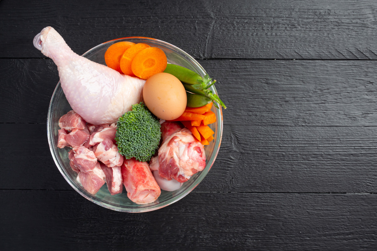 Ingredientes de alimentos para mascotas frescos y saludables en superficie oscura