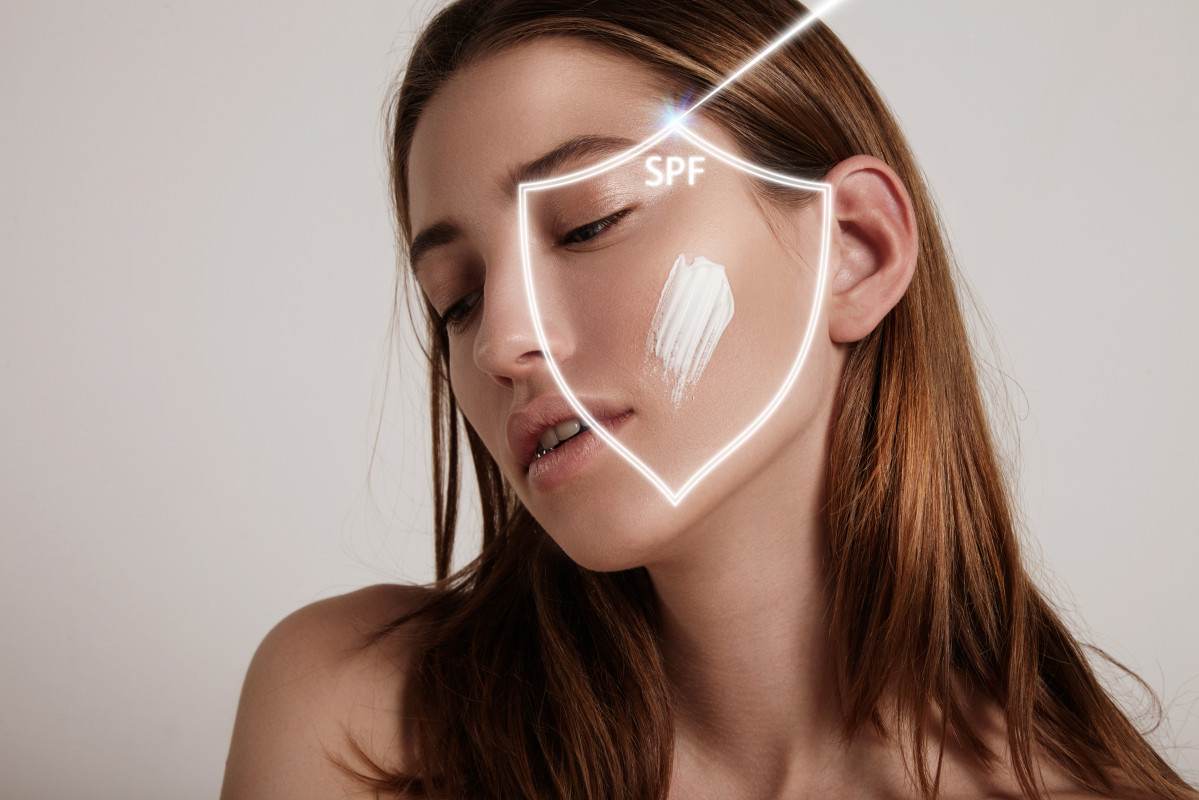 La cara de la mujer en un escudo hace que la proteccion spf contra el rayo
